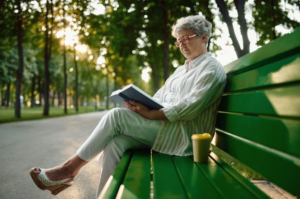 Dranny reading a book on the bench in summer park