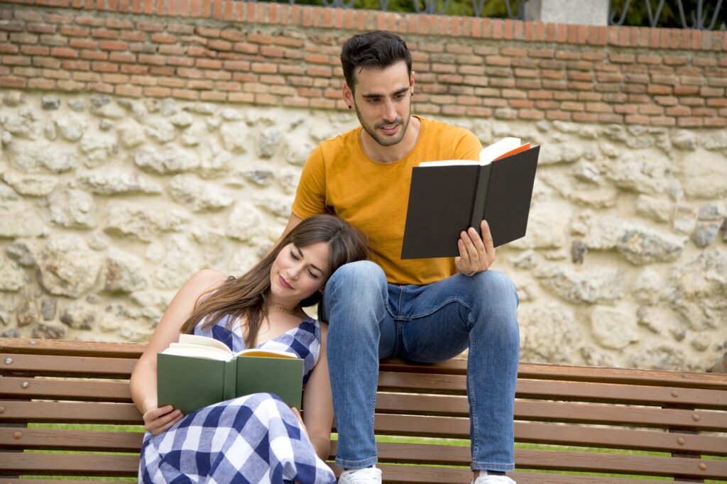 Woman leaning on her partner while reading a book in a park